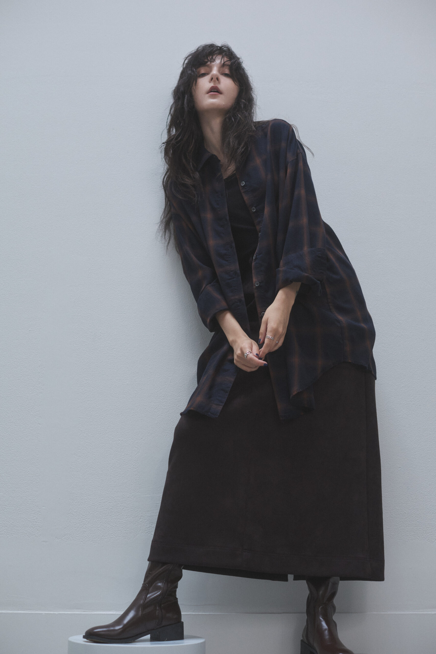 ウィンドウペーンネルシャツとロングスカートを着ている女性モデルの写真