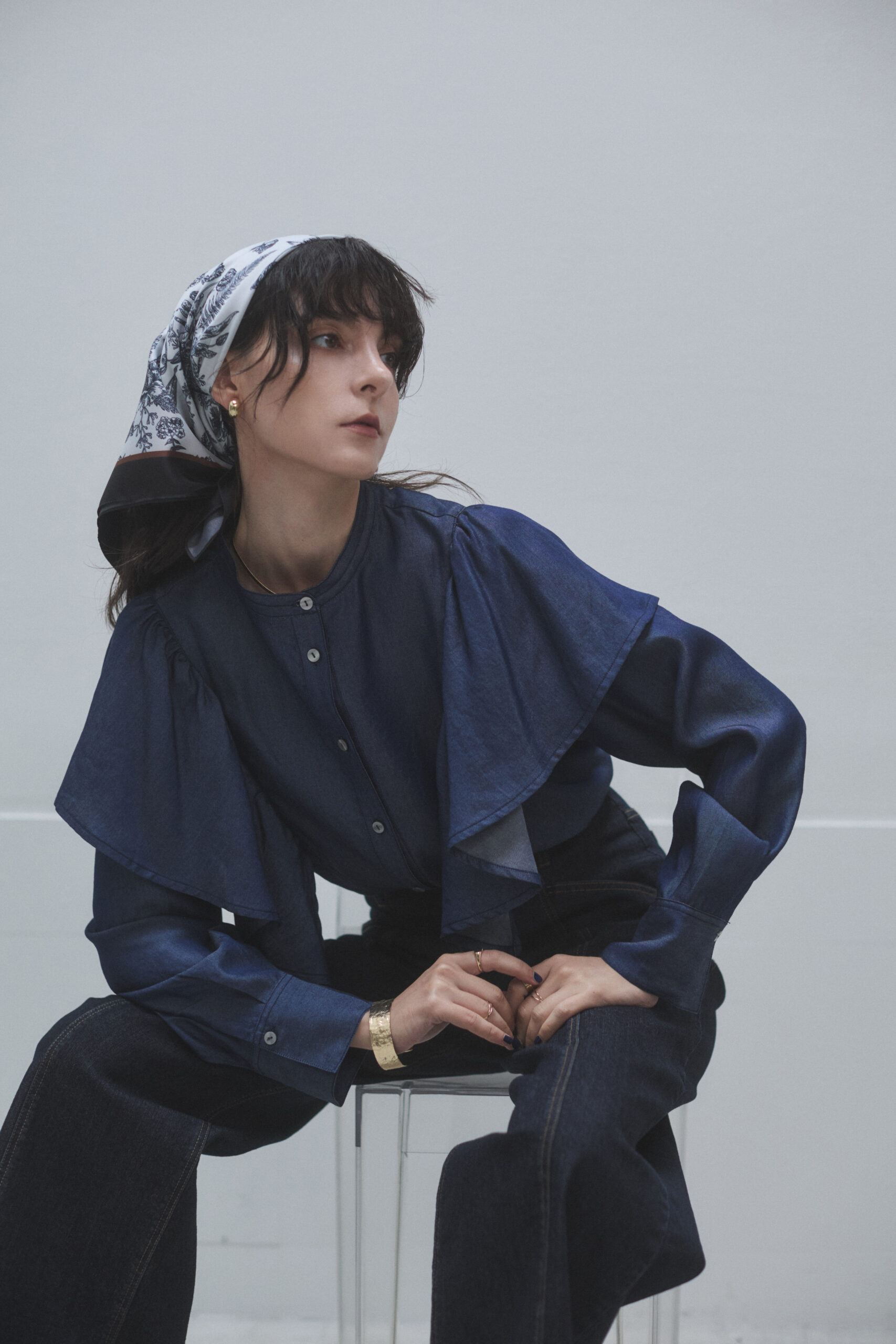濃紺のデニムフリルブラウスとパンツを着ている女性モデルの写真