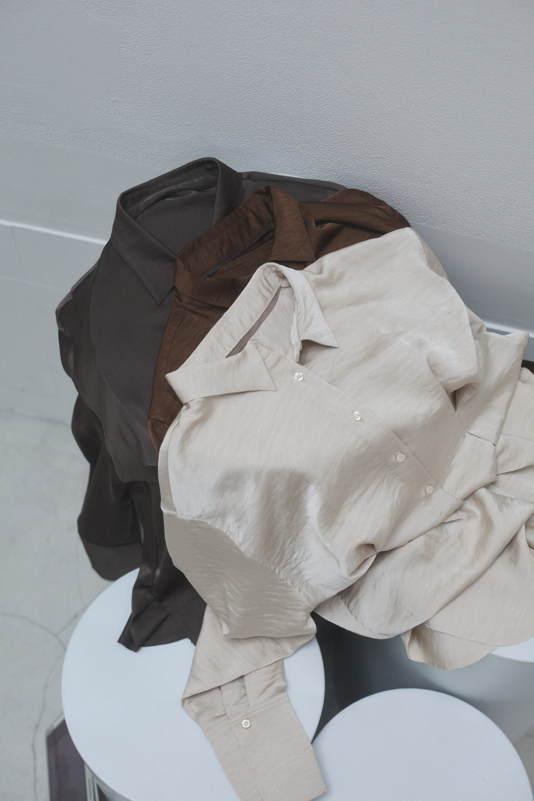 サテンシャツが数枚重なって置かれている写真