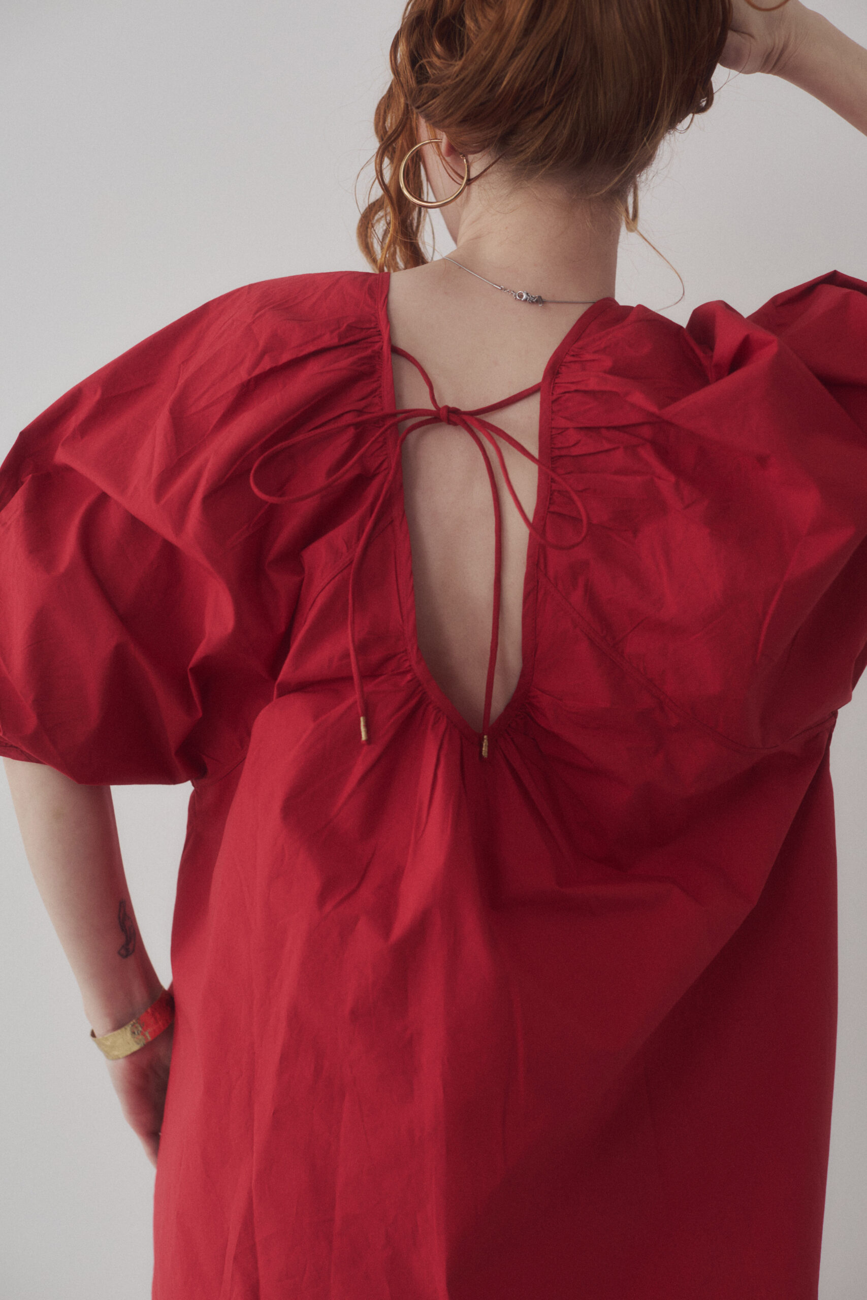 赤いブラウスを着ている女性モデルの背中写真