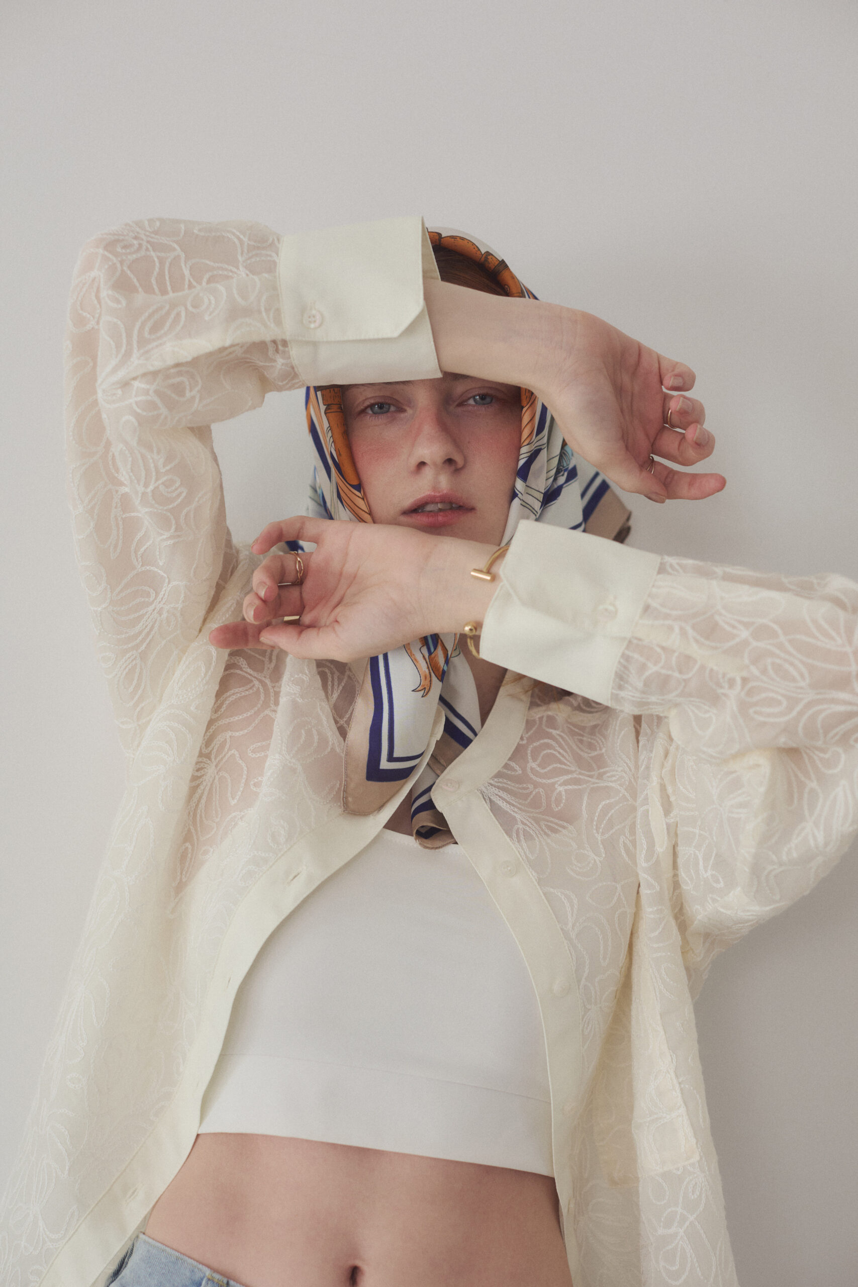 白いタンクトップとブラウスを着て頭にスカーフを巻いている女性モデル写真のバストアップ