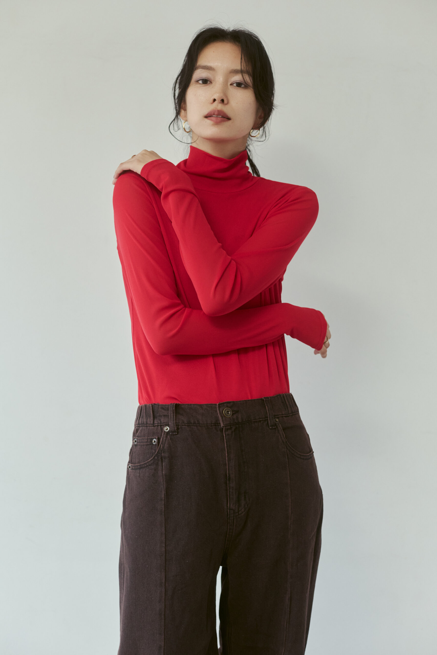 真っ赤なパワーネットトップスと茶色デニムパンツを着ている女性モデル写真